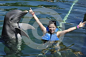 Woman holding a kiss from a dolphin.