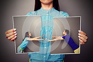 Woman holding the lacerated photo of couple