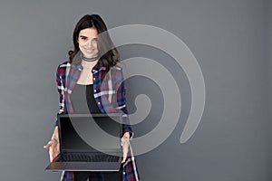 Woman holding a laptop computer with black empty screen