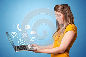 Woman holding laptop with online symbols