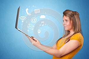 Woman holding laptop with online symbols