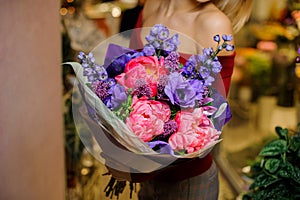 Woman holding a large purple and pink flower bouquet for the Valentine s day