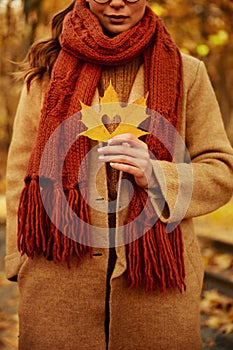 Woman holding leaf with heart shaped hole