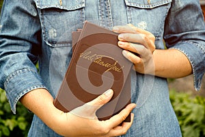 Woman holding Lev Tolstoy books. Leo Tolstoys handwritten signature in Russian on the hardcover of the book