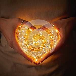 Woman holding lights in the shape of a heart