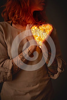 Woman holding lights in the shape of a heart