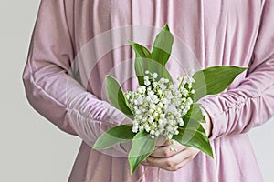 Woman holding lily of valley flower bouquet