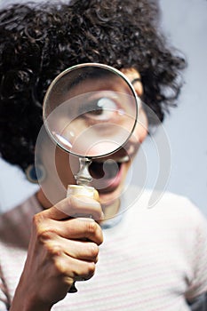 Woman holding and looking through a magnifier