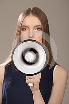 Woman holding a loud speaker. Portrait of a beautiful fashion woman