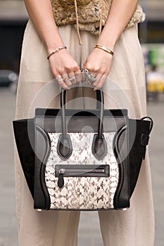 Woman holding purse, handbag with rings on fingers photo