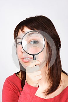Woman holding magnifier and looking through it photo