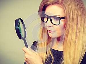 Woman holding magnifying glass investigating