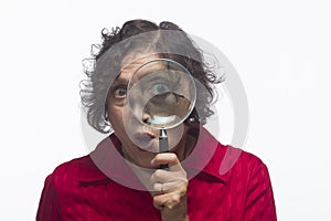 Woman holding magnifying glass up to her eye, horizontal