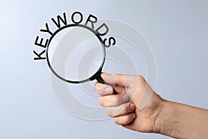 Woman holding magnifying glass with word keyword