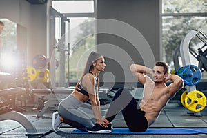 Woman holding man feet down as he doing sit up exercises.