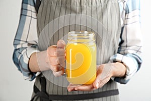 Woman holding mason jar of immunity boosting drink in hands, closeup