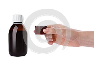 Woman holding measuring cup with syrup  on white, closeup. Cough and cold medicine