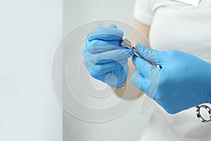 Woman holding medical injection syringe in her outstretched hand towards the camera. Selective focus, copy space Blue