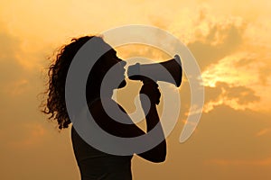 Woman holding megaphone at sunset