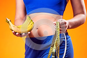 Woman holding meter and banana. People, fitness and healthcare concept