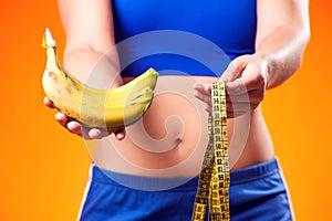 Woman holding meter and banana. People, fitness and healthcare concept