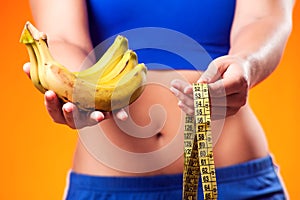 Woman holding meter and banana. People, fitness and healthcare concept