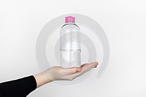 A woman is holding an micellar water. Place for your text. The concept of hazardous substances in cosmetics and household