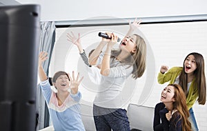 Woman holding microphone and singing at karaoke