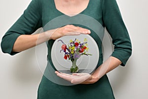 Woman Holding A Mirror And Reflexion of Different Flowers In Vase