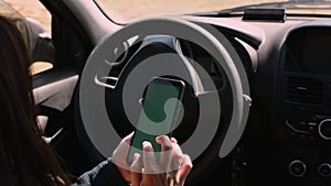 Woman holding mobile phone, smartphone in car interior