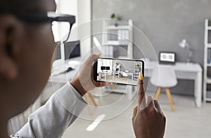 Woman holding mobile phone and taking photo of interior in office or apartment for rent