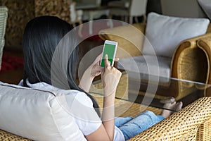 Woman holding mobile smart phone with green screen, Selective focus.