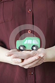 Woman Holding Model Car In Palm Of Hand