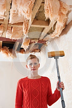 Woman Holding Mop Under Damaged Ceiling