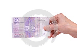 Woman holding a 20 Moroccon Dirham banknote in her hand on a white background photo
