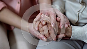 Woman holding mother hands closeup, nursing home support, family love and help