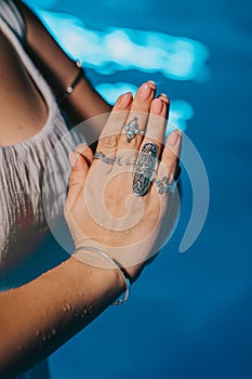 Woman holding namaste in clean water. Palms with gypsy boho rings. Meditation, praying, gratitude, purity background.