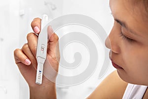 Woman holding negative pregnant test result photo