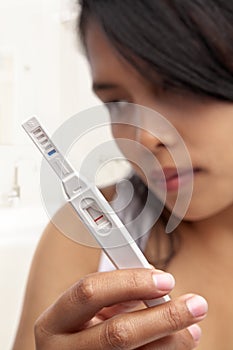 Woman holding negative result pregnancy test