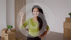 Woman Holding New House Key Standing Among Moving Boxes Indoor