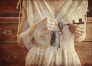 Woman holding old key and lock in a hands