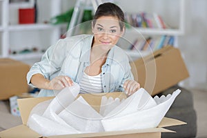 Woman holding open cardboard box for moving into new house