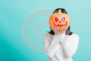 Woman holding orange model pumpkins at her head
