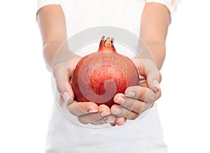 Woman holding out hands with red pomegranate