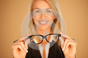 Woman holding out her spectacles