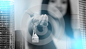 Woman holding out house keys, light effect; multiple exposure