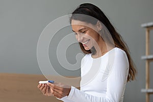 Woman holding ovulation test checks chances of getting pregnant