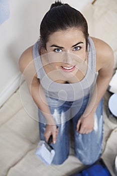 Woman Holding Paint Brush In Unrenovated House