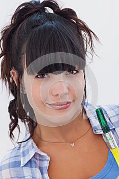 Woman holding paintbrush smiling at camera