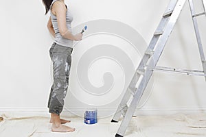 Woman Holding Paintbrush In Unrenovated House photo